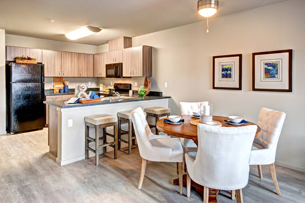 A kitchen with a table and chairs.