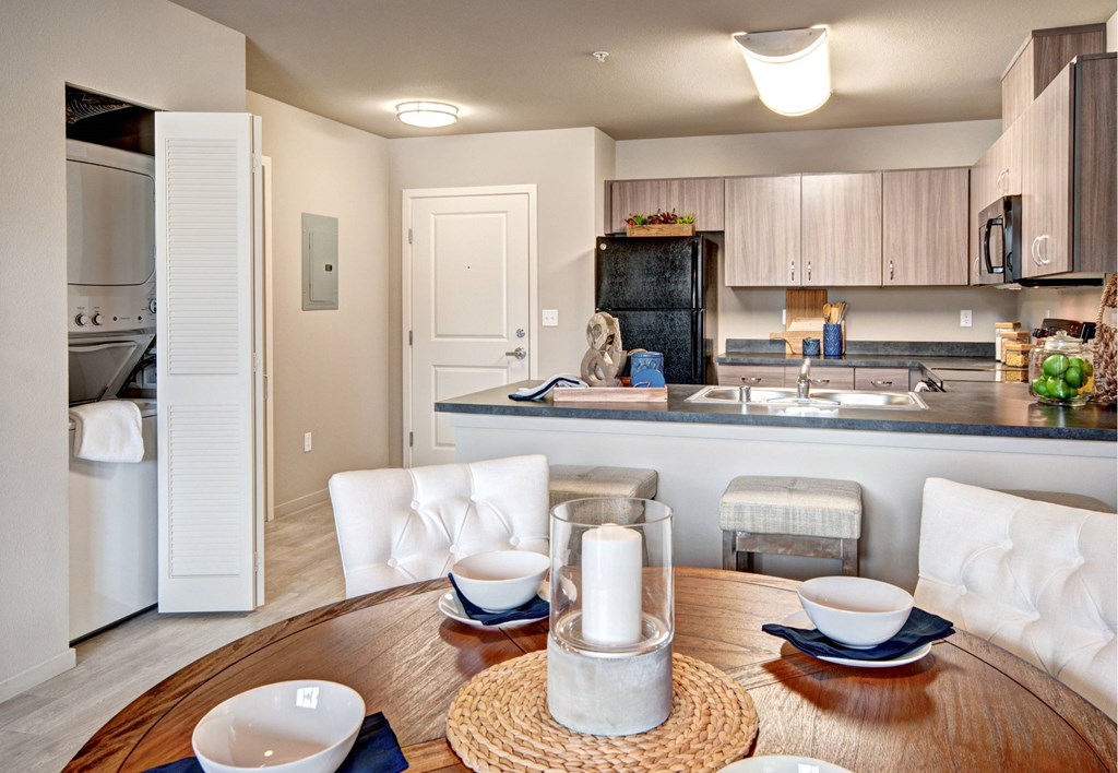 A modern kitchen with a dining table set for two.
