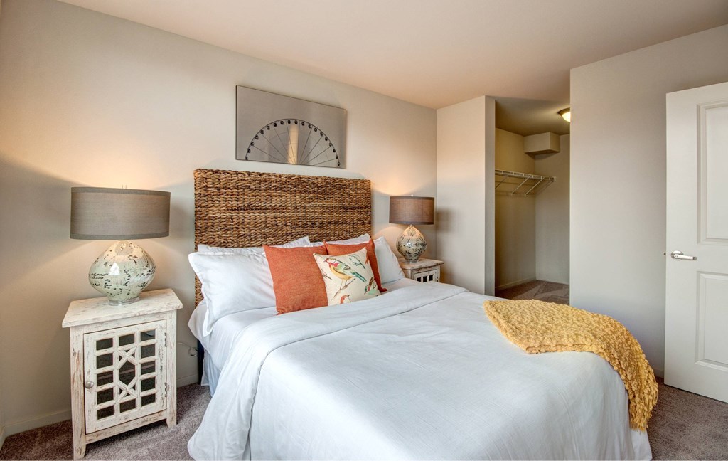 A bedroom with a white bed and a wicker headboard.