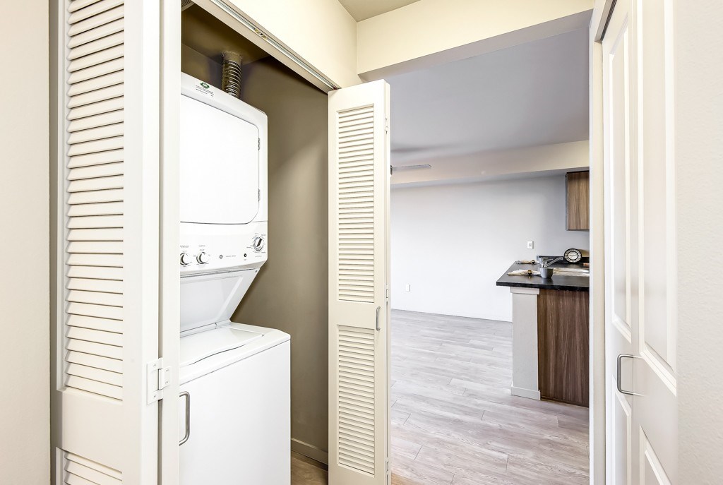 A white refrigerator is in a kitchen next to a white door.