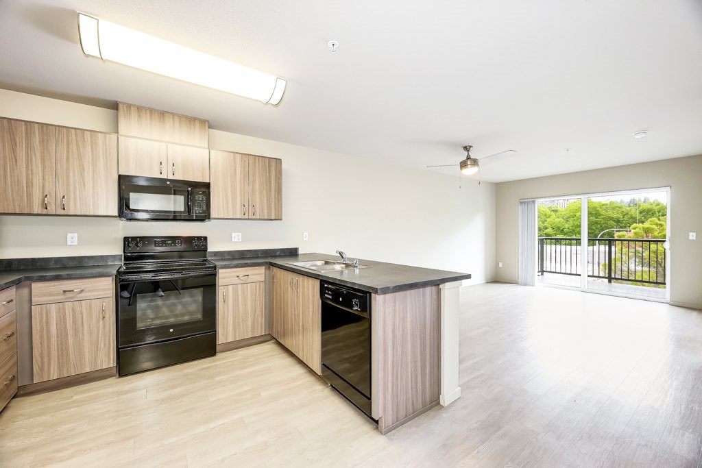 A kitchen with wooden cabinets and black appliances.