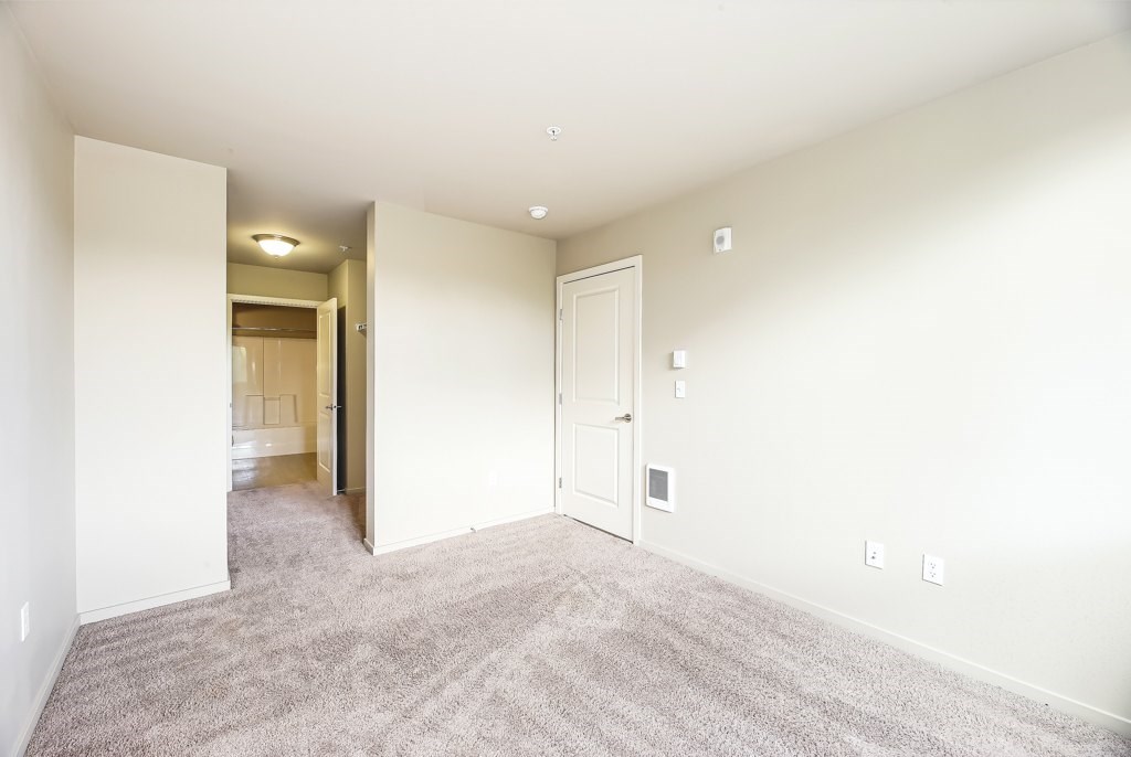 A room with a carpeted floor and white walls.