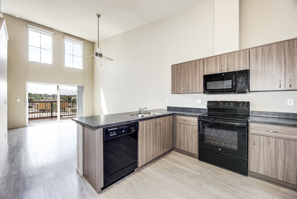 A kitchen with a black oven and wooden cabinets.