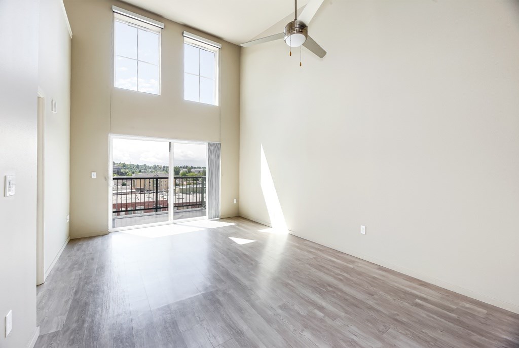 A room with a balcony and a ceiling fan.