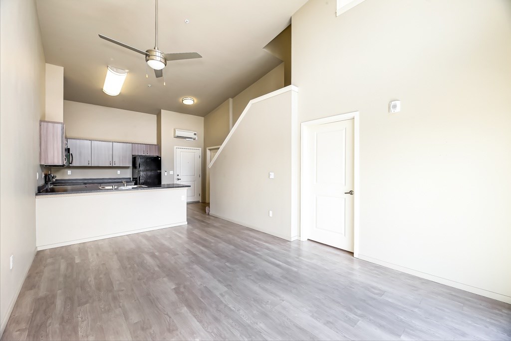 A spacious kitchen with a fan on the ceiling.