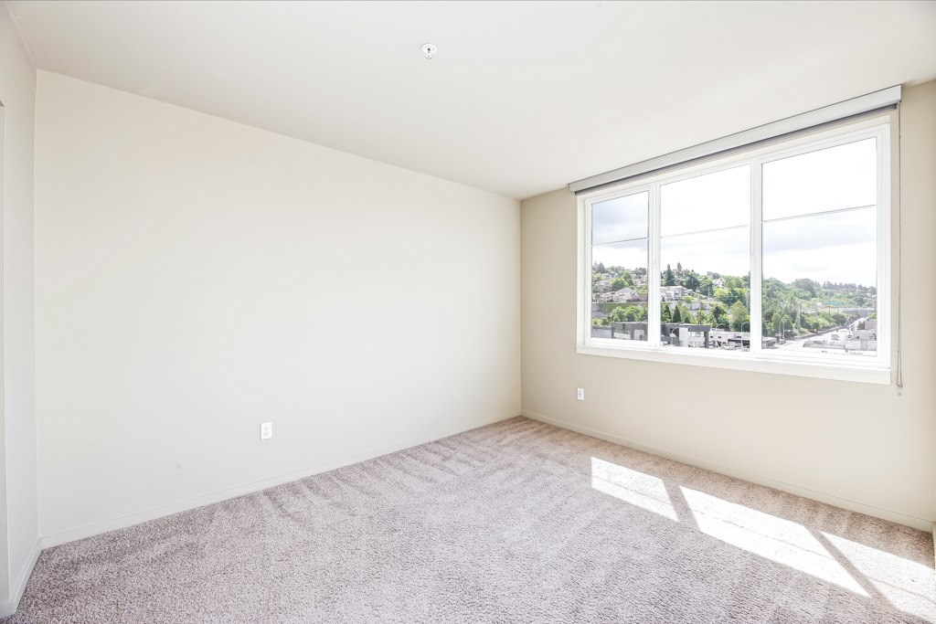 A room with a large window and carpeted floor.