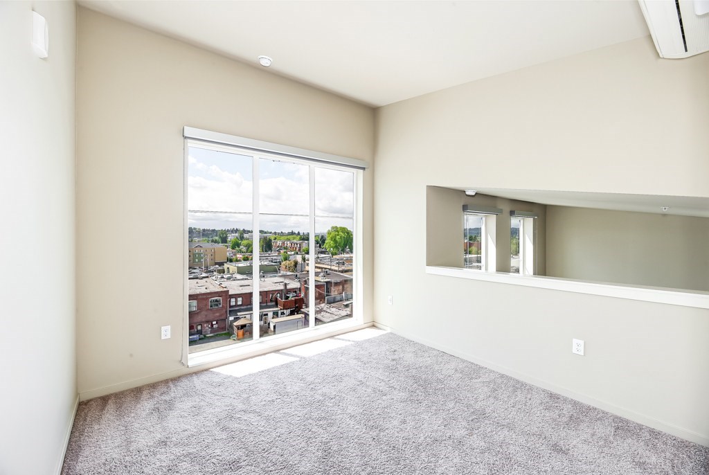 A room with a large window overlooking a cityscape.