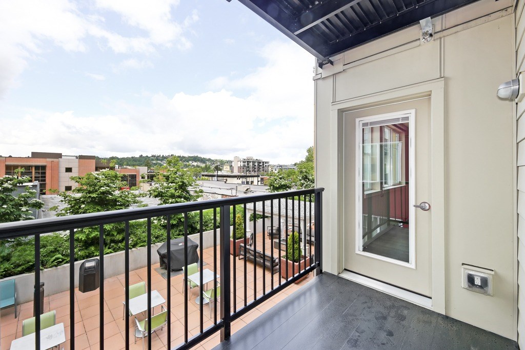 A balcony with a black railing and a white door.