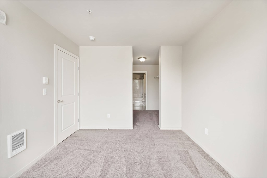 A room with a carpeted floor and white walls.