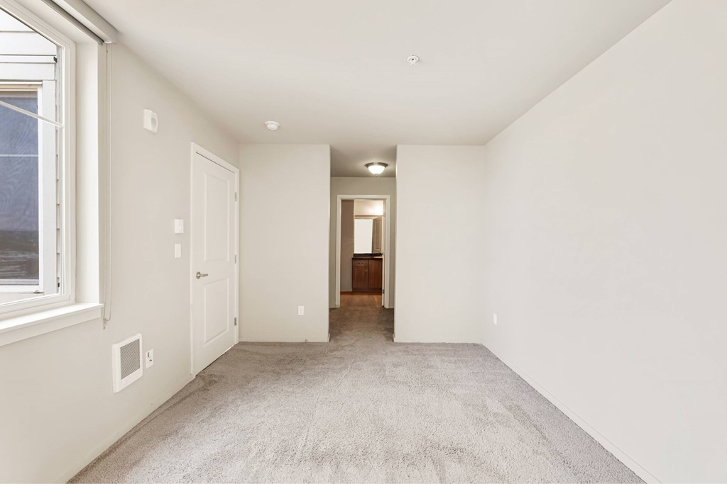 A room with white walls and carpeted floor.