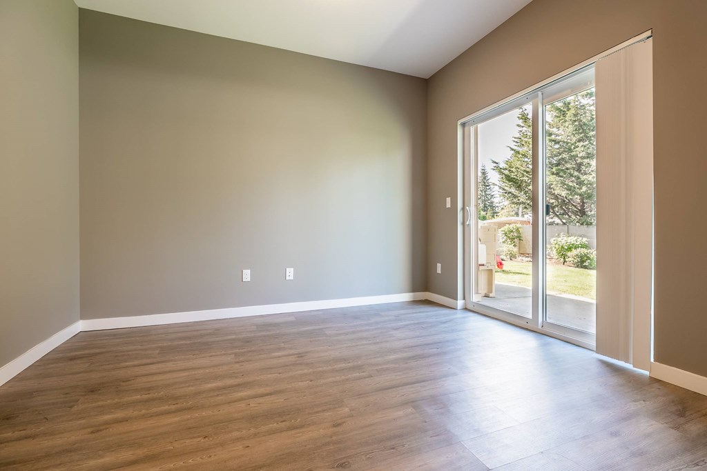 A room with a sliding glass door leading to a backyard.