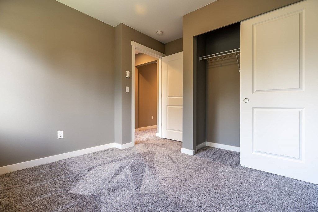 A room with a carpeted floor and a doorway leading to another room.