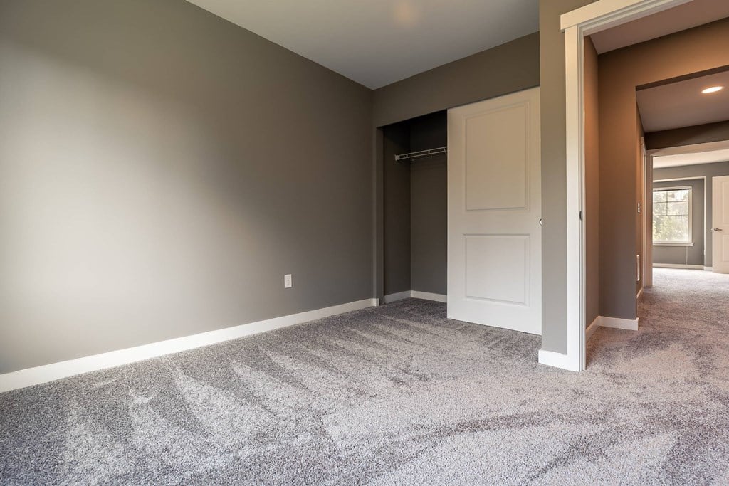 A room with a carpeted floor and a white door.