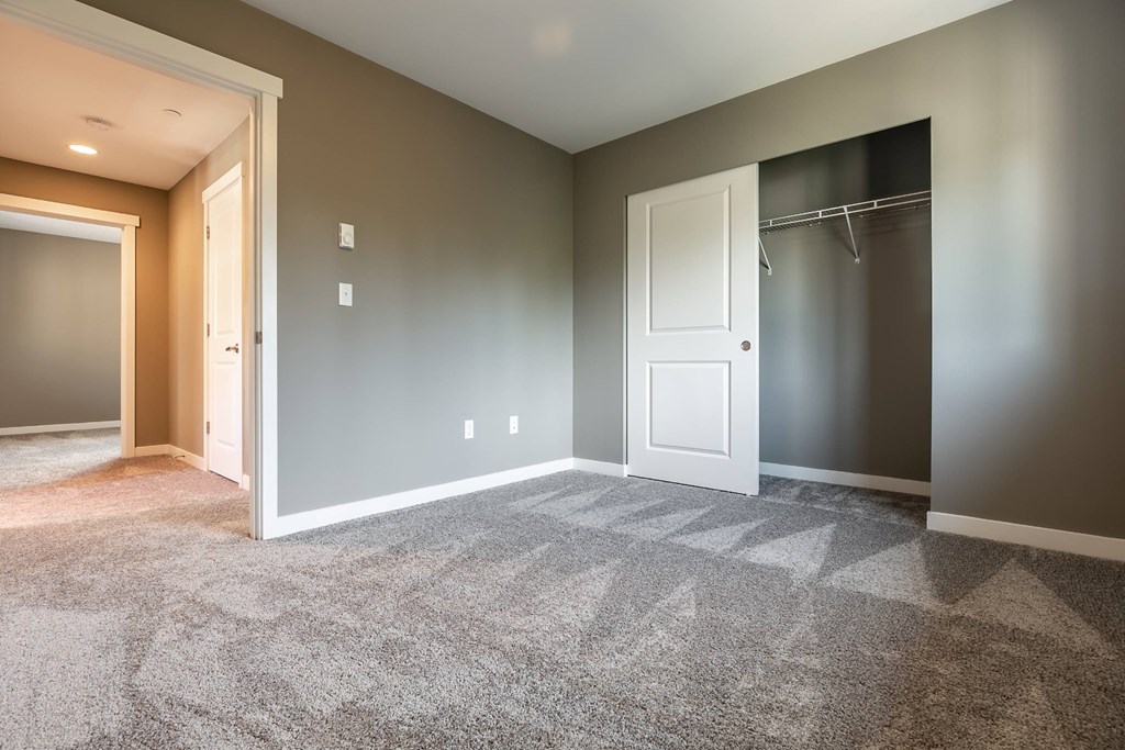 A room with a carpeted floor and a white door.
