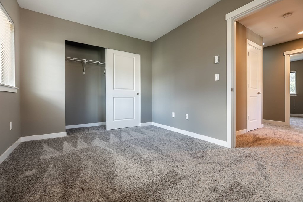 A room with a carpeted floor and a white door.