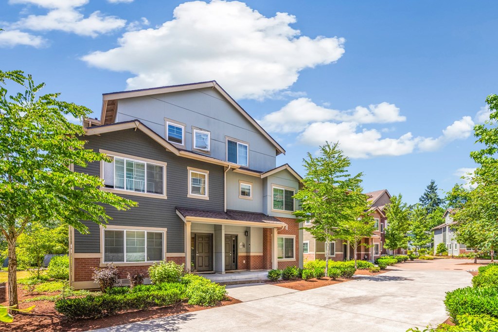 A modern house with a grey exterior and a large front yard.