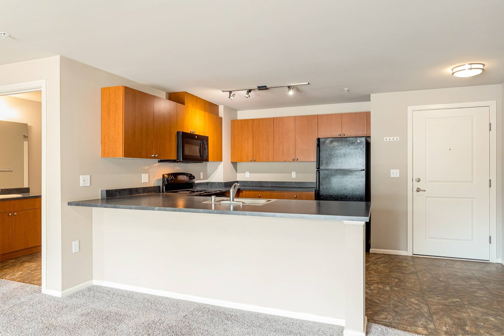A kitchen with a white island and wooden cabinets.
