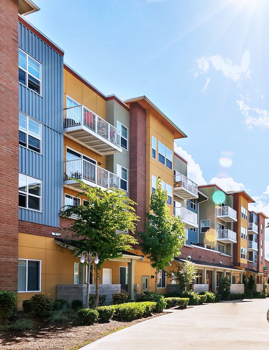 A sunny day at a modern apartment complex with a clear blue sky.