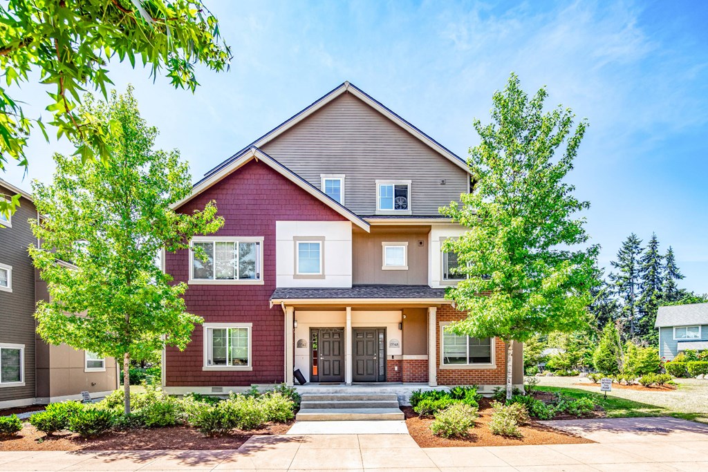 A red house with a brown roof and a white door.