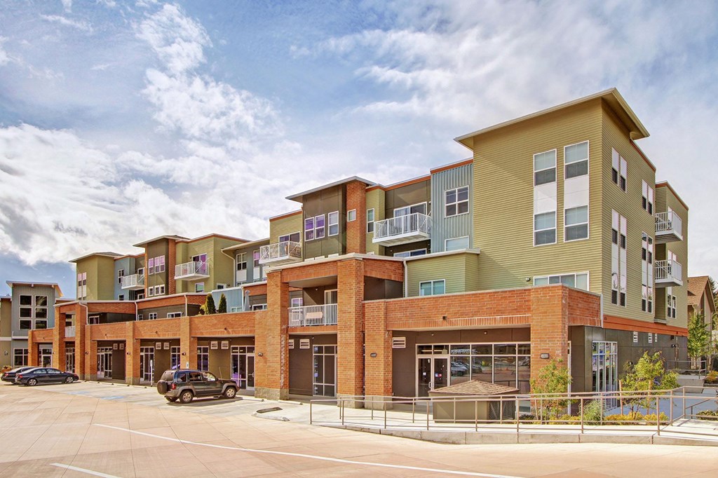 A large multi-story building with a parking lot in front.
