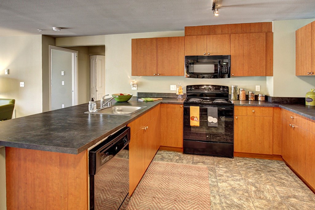A kitchen with wooden cabinets and a black stove top oven.