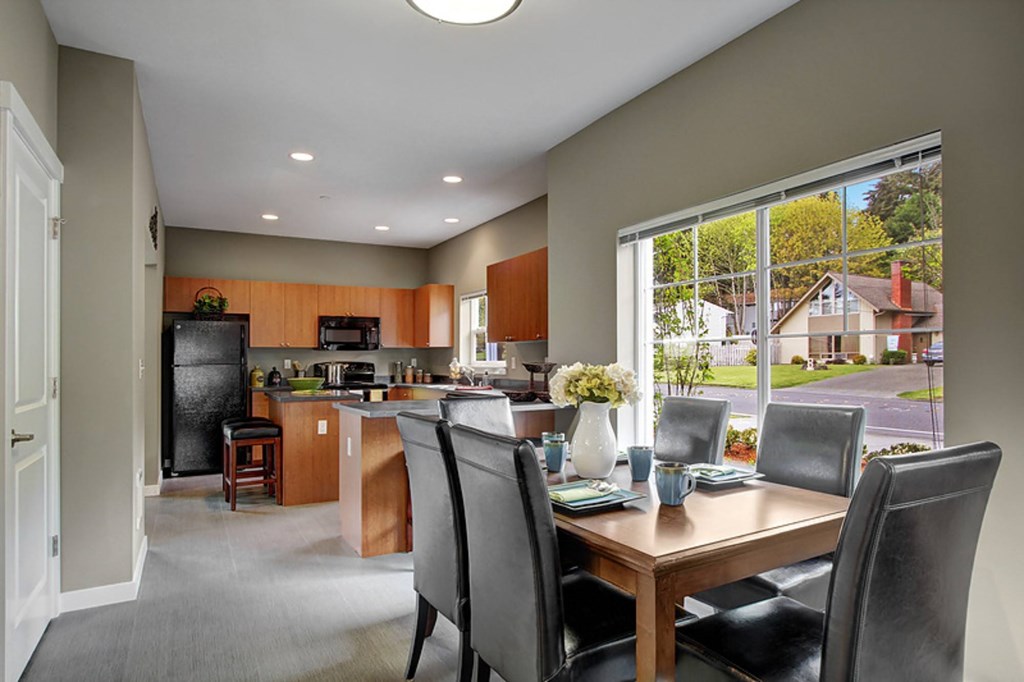 A kitchen with a table and chairs in front of a window.