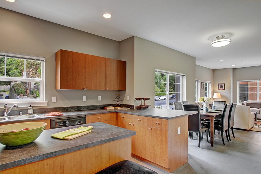 A kitchen with wooden cabinets and a green bowl on the counter.