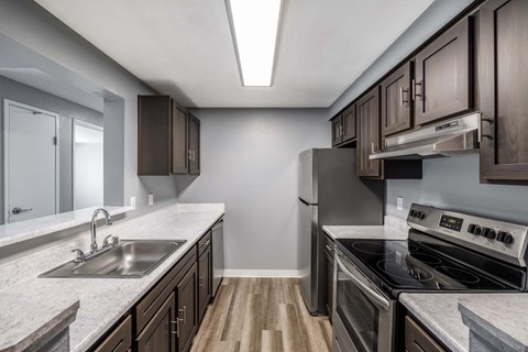 A kitchen with a stove top oven and a sink.