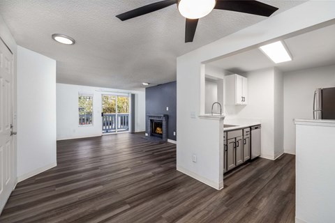 A living room with a fireplace and a ceiling fan.