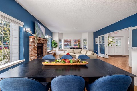 A dining room with a black table and blue chairs.