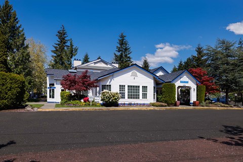 A white house with a red roof and a blue sign on the front.
