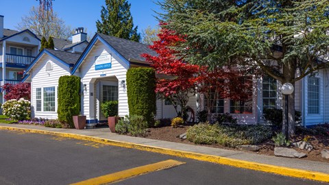 A small white house with a blue sign on the front door.