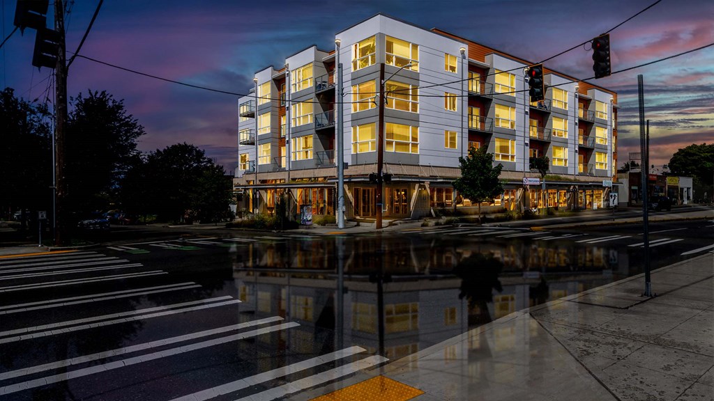 A modern apartment building is lit up at dusk.