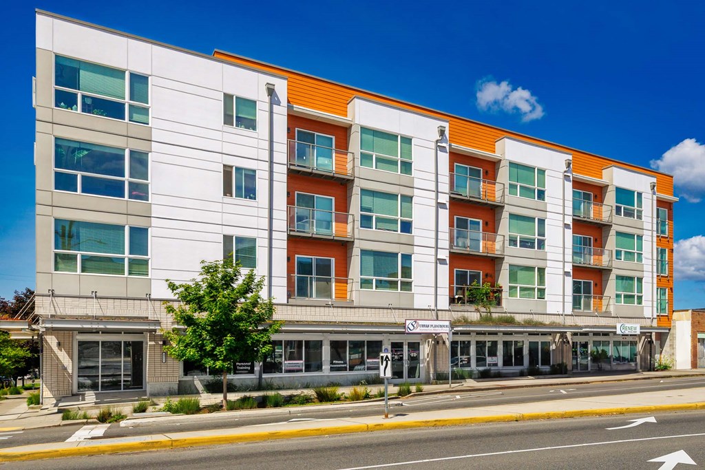 A modern multi-story building with a white and orange facade.