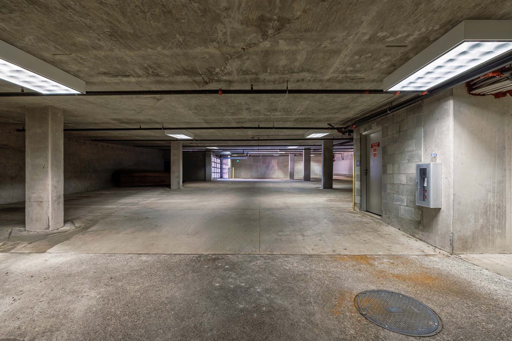 A large, empty parking garage with concrete pillars and a concrete floor.
