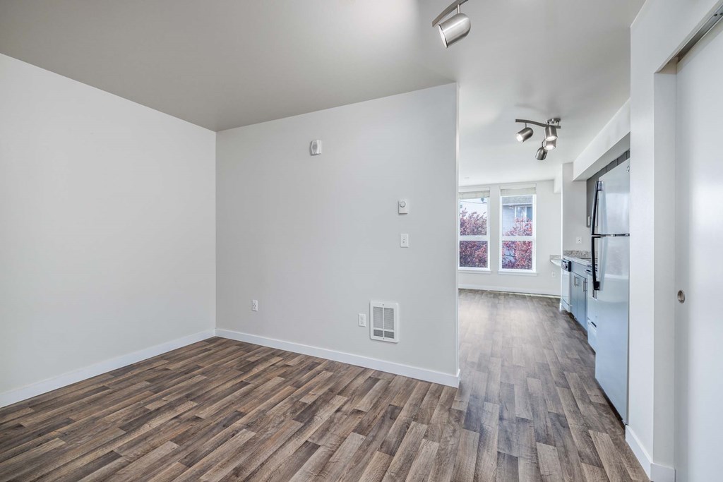 A room with wooden flooring and white walls.