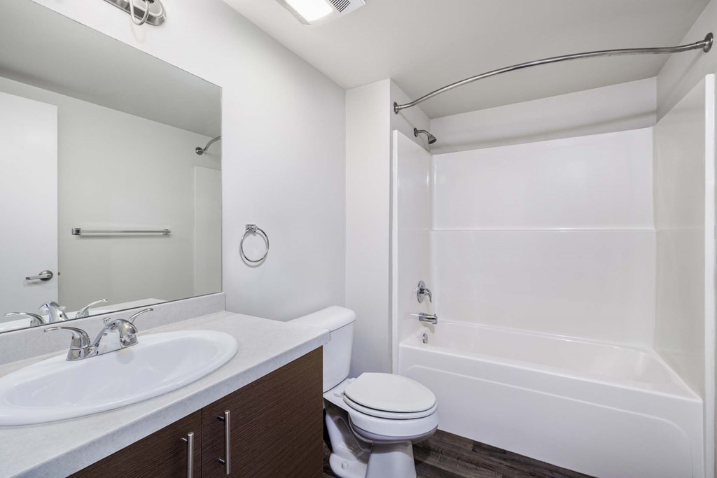 A white bathroom with a toilet, sink, and bathtub.