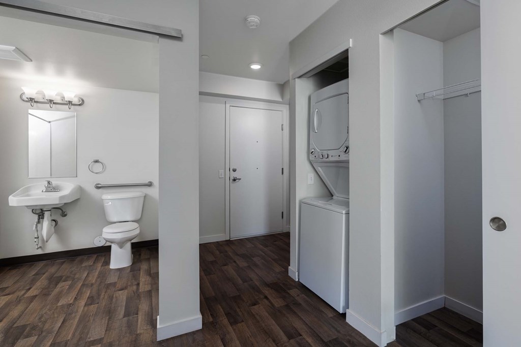 A bathroom with a toilet, sink, and a cabinet.