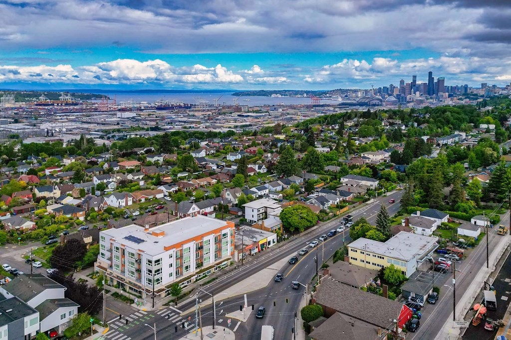 A cityscape with a large building in the foreground and a city skyline in the distance.