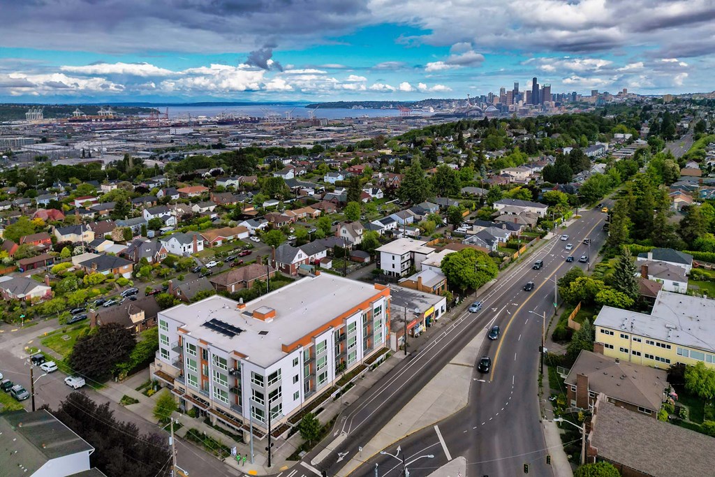A cityscape with a large building in the foreground and a city skyline in the distance.