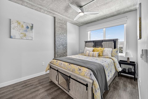 A bedroom with a large bed and a ceiling fan.