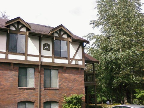 A building with a brown and white facade has a window with a letter A on it.
