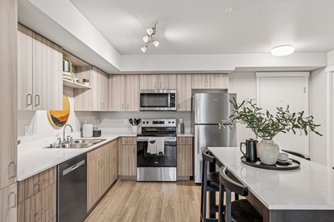 A modern kitchen with wooden cabinets and stainless steel appliances.