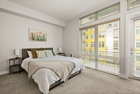 A bedroom with a large bed and a painting on the wall.