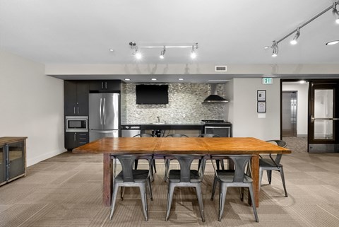 A modern kitchen with a wooden table and chairs.