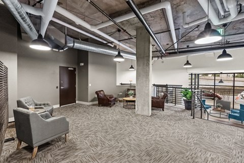 A spacious office with grey carpeting and a variety of seating options.