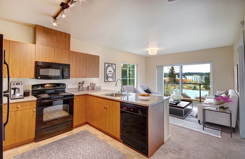 A kitchen with wooden cabinets and a black oven.