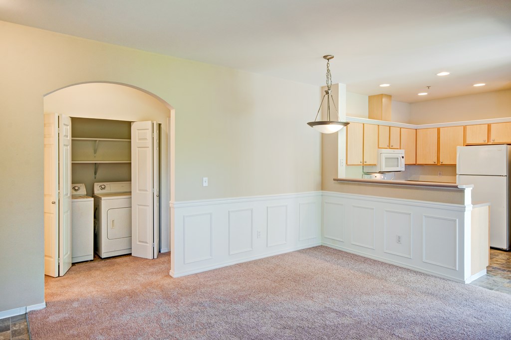 A kitchen with white cabinets and a refrigerator with the door open.