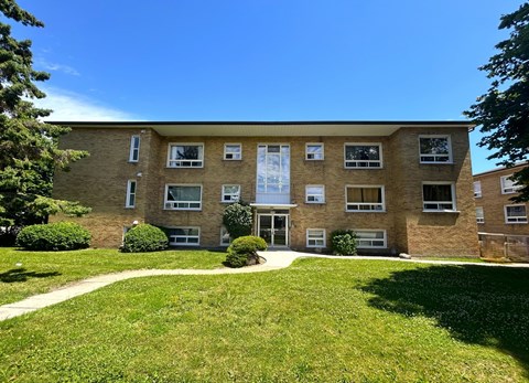 A building with a green lawn in front.