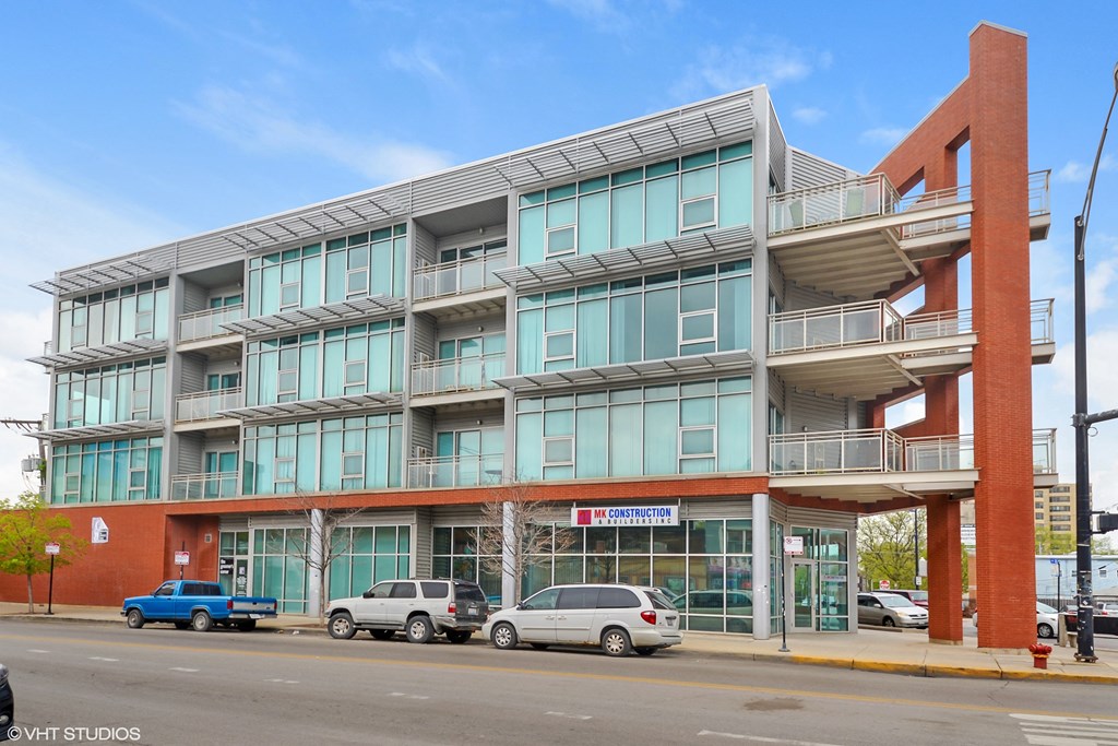 a large apartment building with cars parked in front of it